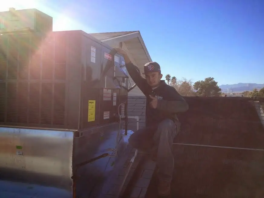 HVAC technician performing AC Tune-Up on a rooftop unit in El Monte
